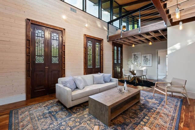 5607 Jim Hogg Ave, Austin, TX 78756 - living area featuring baseboards, wooden walls, plenty of natural light, wood finished floors, and a high ceiling