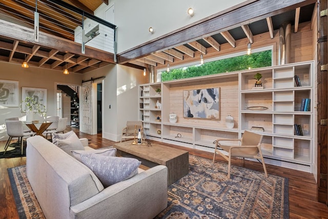 5607 Jim Hogg Ave, Austin, TX 78756 - living room featuring a barn door, wood finished floors, beam ceiling, and baseboards