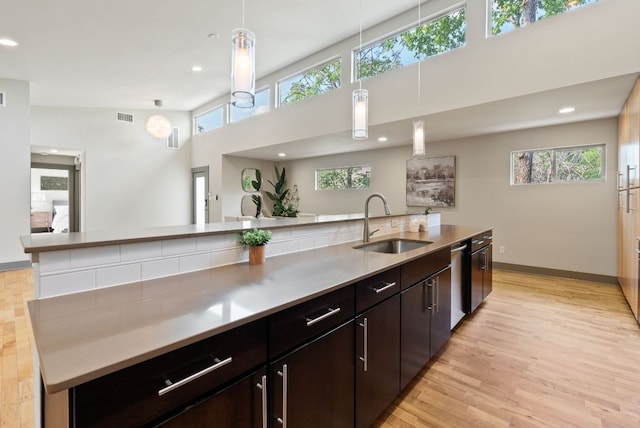 5607 Jim Hogg Ave, Austin, TX 78756 - kitchen with a sink, stainless steel dishwasher, light wood finished floors, hanging light fixtures, and recessed lighting