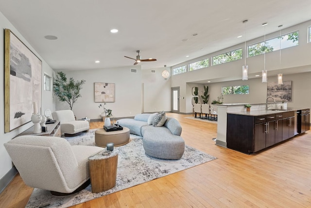 5607 Jim Hogg Ave, Austin, TX 78756 - living room with recessed lighting, healthy amount of natural light, light wood-style floors, a ceiling fan, and baseboards