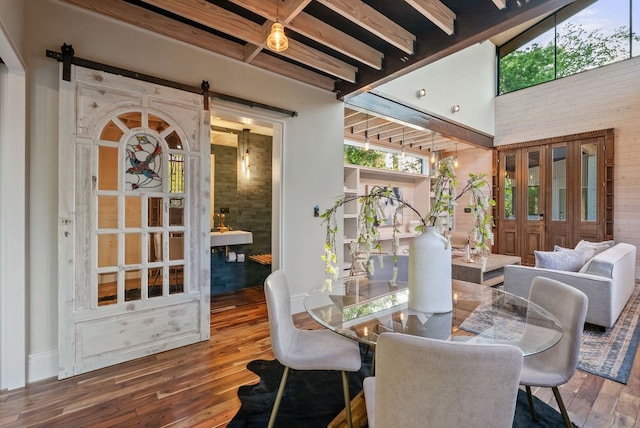 5607 Jim Hogg Ave, Austin, TX 78756 - dining room with a barn door, wood finished floors, and baseboards