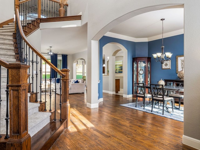 17012 Rush Pea Cir, Austin, TX 78738 - entryway with arched walkways, wood finished floors, a chandelier, stairway, and crown molding
