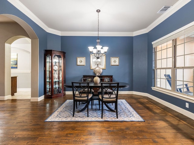 17012 Rush Pea Cir, Austin, TX 78738 - dining space featuring a chandelier, wood finished floors, baseboards, crown molding, and arched walkways