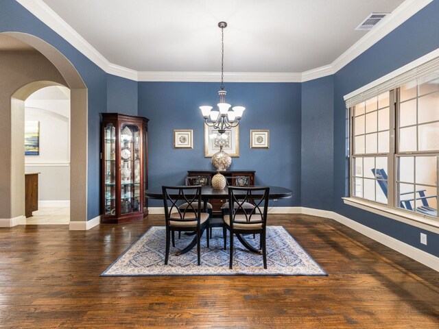 17012 Rush Pea Cir, Austin, TX 78738 - dining room with a chandelier, wood finished floors, crown molding, and arched walkways
