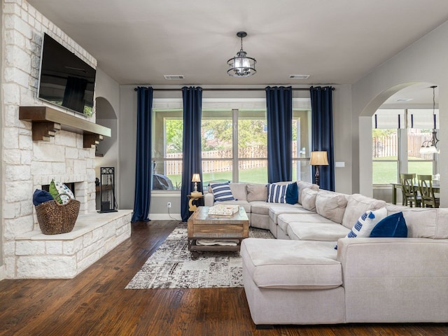 17012 Rush Pea Cir, Austin, TX 78738 - living area featuring arched walkways, wood finished floors, baseboards, and a stone fireplace