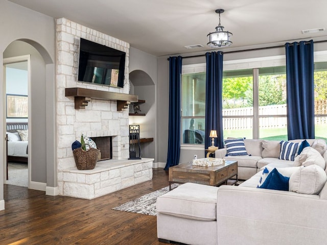17012 Rush Pea Cir, Austin, TX 78738 - living area with arched walkways, baseboards, wood finished floors, and a fireplace
