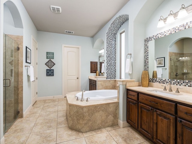 17012 Rush Pea Cir, Austin, TX 78738 - bathroom featuring a stall shower, two vanities, a garden tub, and tile patterned flooring
