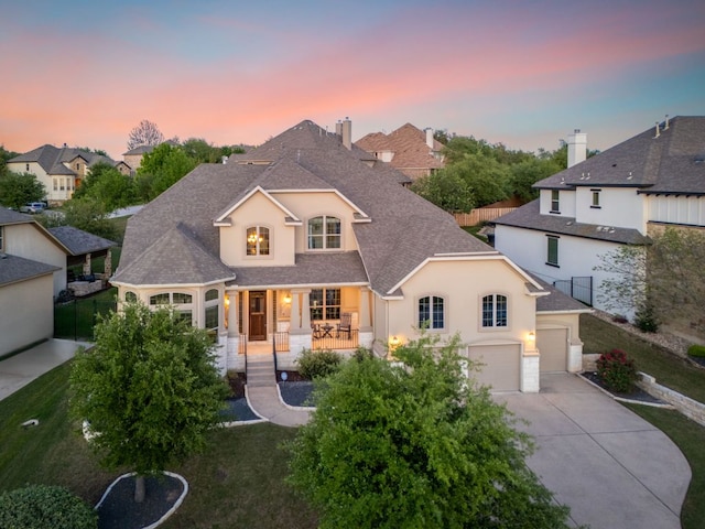 17012 Rush Pea Cir, Austin, TX 78738 - french country style house featuring concrete driveway, a porch, a shingled roof, stucco siding, and a residential view