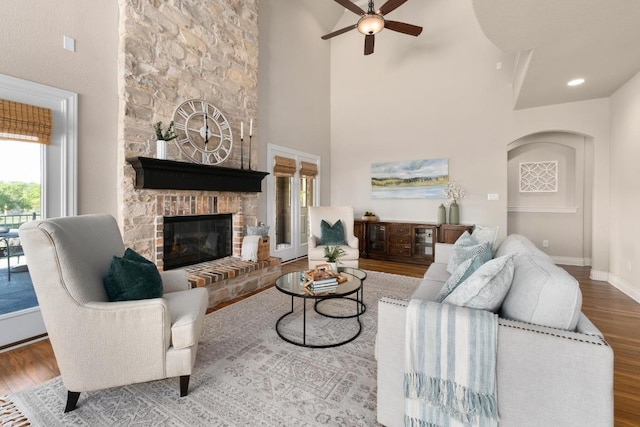 404 Oak Meadow Dr, Georgetown, TX 78628 - living room with ceiling fan, wood finished floors, a stone fireplace, and a towering ceiling