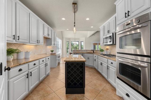 404 Oak Meadow Dr, Georgetown, TX 78628 - kitchen featuring appliances with stainless steel finishes, recessed lighting, a peninsula, backsplash, and pendant lighting