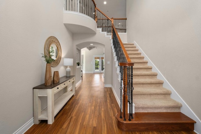 404 Oak Meadow Dr, Georgetown, TX 78628 - staircase featuring arched walkways, wood finished floors, and a towering ceiling