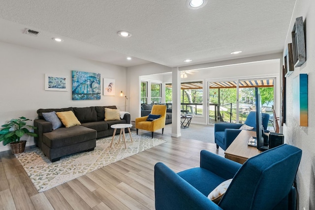 1707 Aztec Trl, Kingsland, TX 78639 - living room featuring a textured ceiling, light wood-type flooring, recessed lighting, and baseboards
