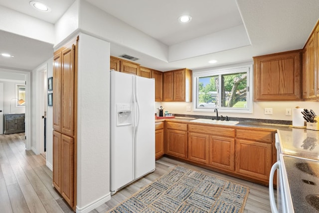 1707 Aztec Trl, Kingsland, TX 78639 - kitchen with white appliances, a sink, light wood-type flooring, brown cabinetry, and recessed lighting