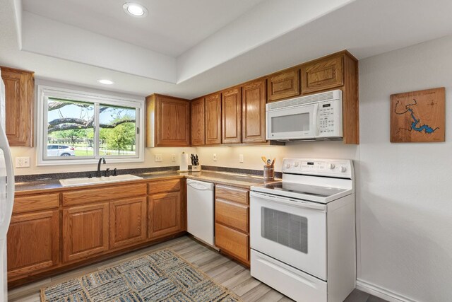 1707 Aztec Trl, Kingsland, TX 78639 - kitchen featuring white appliances, a sink, brown cabinets, dark countertops, and recessed lighting