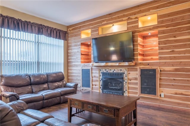 living area with wood walls, wood finished floors, and a fireplace