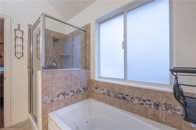 bathroom with a shower stall, lofted ceiling, and a tub with jets