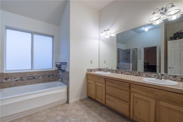 bathroom featuring a stall shower, a sink, and lofted ceiling