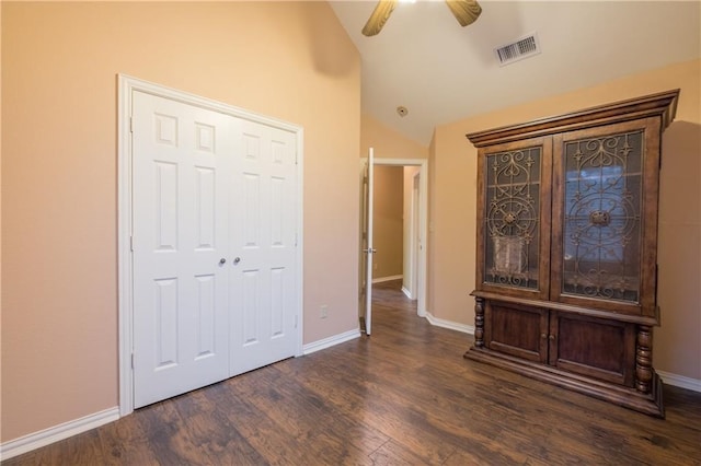 unfurnished bedroom with lofted ceiling, visible vents, baseboards, and wood finished floors