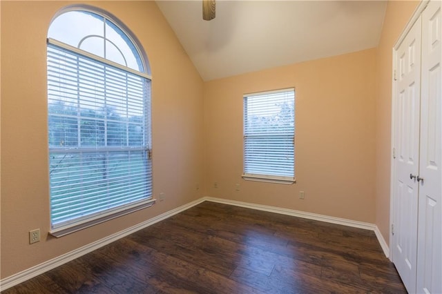 unfurnished room with dark wood-type flooring, baseboards, and lofted ceiling