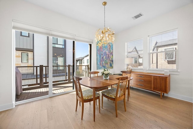 dining area with a chandelier, light wood-type flooring, baseboards, and visible vents
