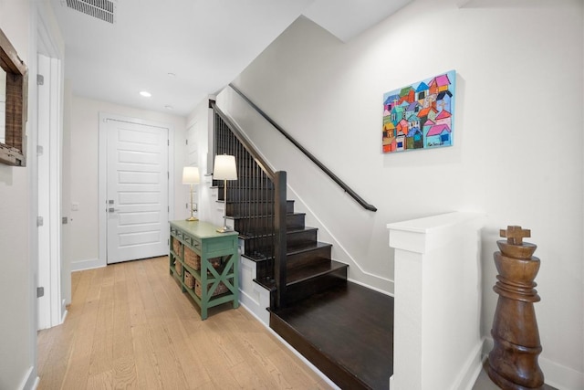 staircase featuring visible vents, baseboards, recessed lighting, and wood finished floors