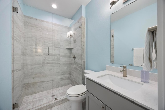 bathroom with toilet, a stall shower, and vanity