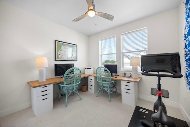 office area featuring ceiling fan, light colored carpet, and baseboards