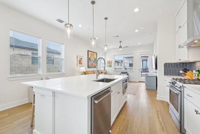 3901 Vantage Dr, Austin, TX 78731 - kitchen with stainless steel appliances, wall chimney exhaust hood, a sink, light wood-style floors, and recessed lighting