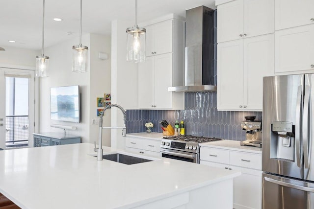 3901 Vantage Dr, Austin, TX 78731 - kitchen featuring appliances with stainless steel finishes, wall chimney range hood, a sink, a kitchen island with sink, and backsplash