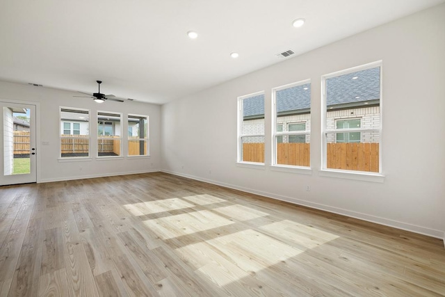 spare room with light wood-type flooring, ceiling fan, baseboards, and visible vents