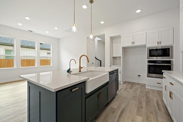 kitchen featuring white cabinetry, built in microwave, stainless steel oven, dishwasher, and a sink
