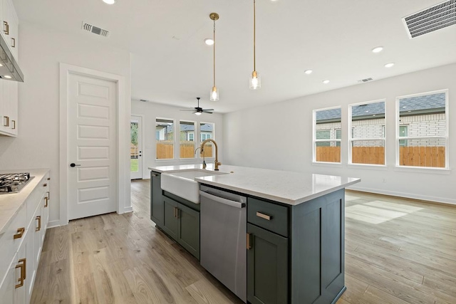 kitchen featuring visible vents, light wood-type flooring, a sink, and appliances with stainless steel finishes