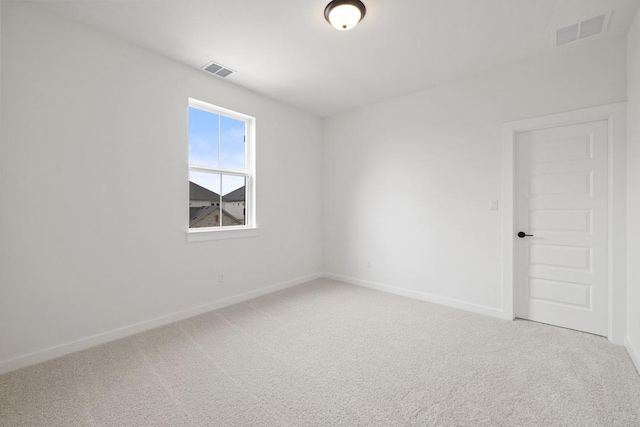 unfurnished room with visible vents, baseboards, and light colored carpet