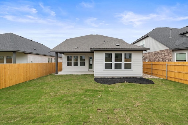 rear view of house with a patio area, a fenced backyard, and a yard