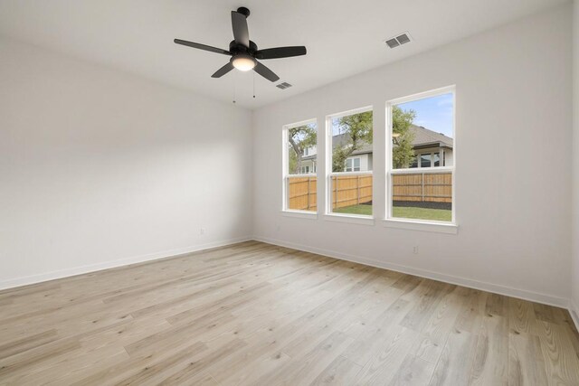 empty room featuring light wood-style flooring, baseboards, and visible vents