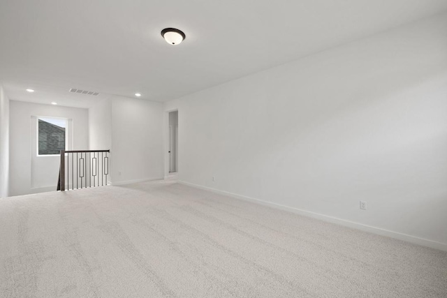 unfurnished room with light carpet, baseboards, visible vents, and recessed lighting
