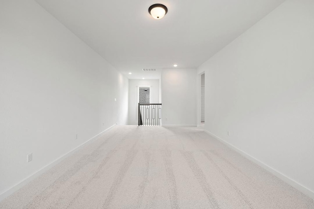 carpeted empty room featuring recessed lighting, visible vents, and baseboards