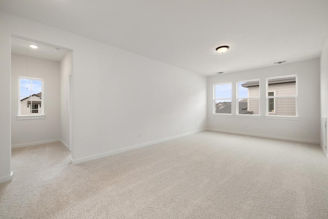 carpeted empty room with baseboards and visible vents