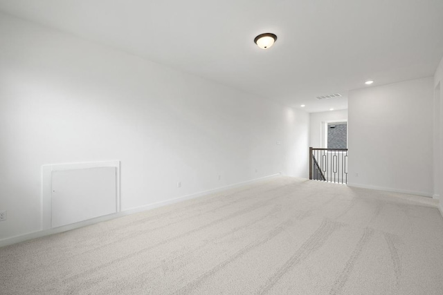 spare room with recessed lighting, carpet, visible vents, and baseboards
