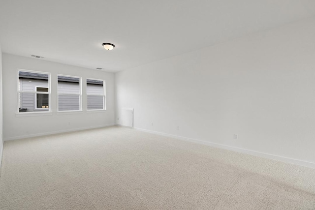 empty room with visible vents, baseboards, and light carpet