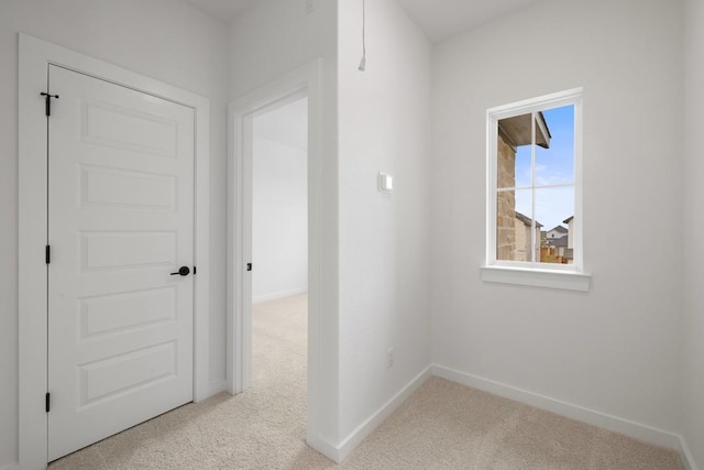 hall featuring baseboards and carpet floors