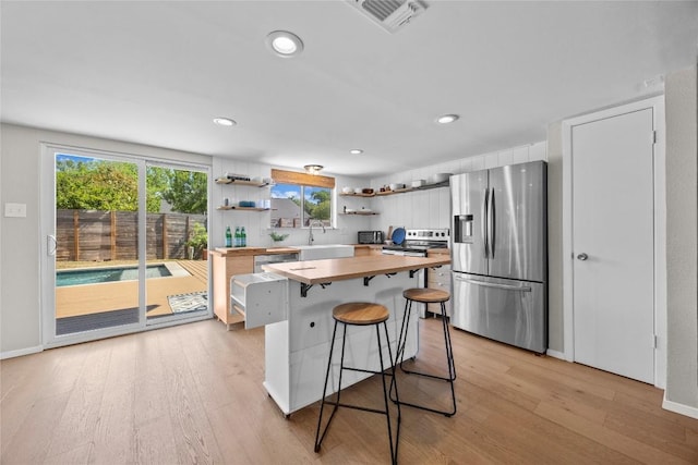 12324 Havelock Dr, Austin, TX 78759 - kitchen with butcher block counters, stainless steel appliances, open shelves, light wood-style flooring, and recessed lighting