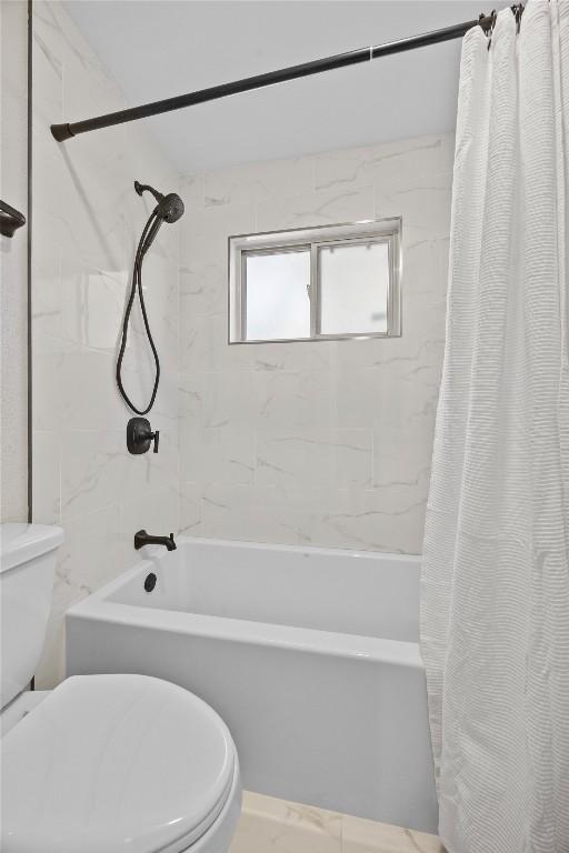 bathroom with toilet and shower / bath combination with curtain