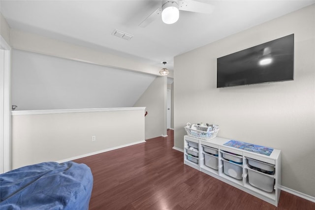 interior space with an upstairs landing, wood finished floors, visible vents, ceiling fan, and vaulted ceiling