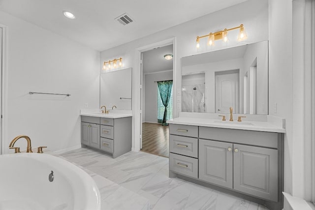 409 Dycus Bnd, Liberty Hill, TX 78642 - bathroom featuring two vanities, a tub, marble look tiles, a shower, and baseboards
