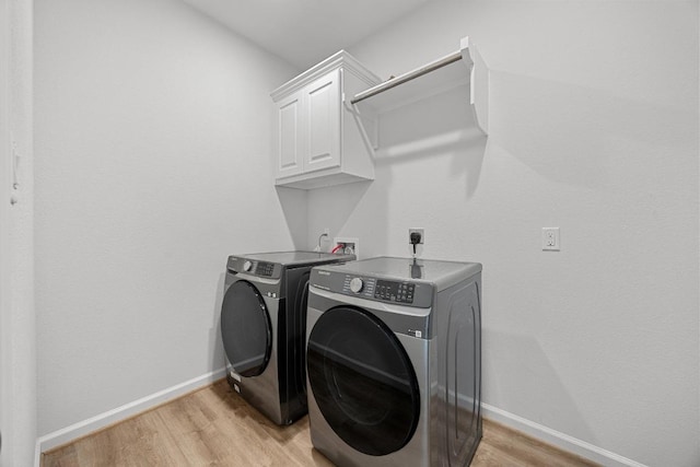 409 Dycus Bnd, Liberty Hill, TX 78642 - washroom featuring cabinet space, independent washer and dryer, light wood-style floors, and baseboards