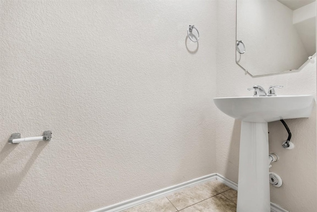 bathroom with baseboards and tile patterned floors