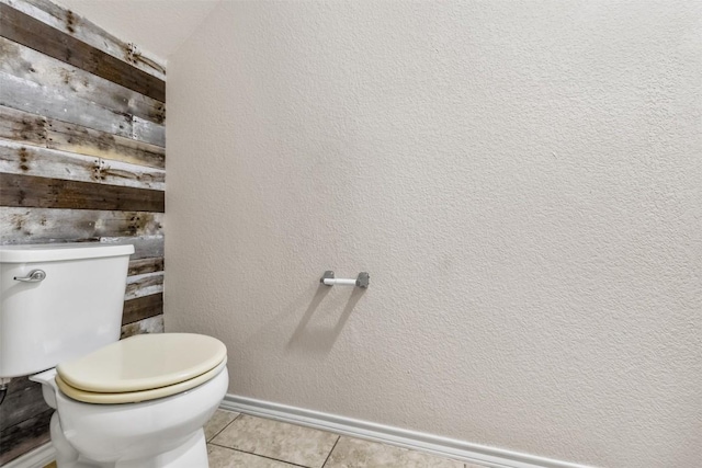 bathroom featuring toilet, baseboards, and tile patterned floors