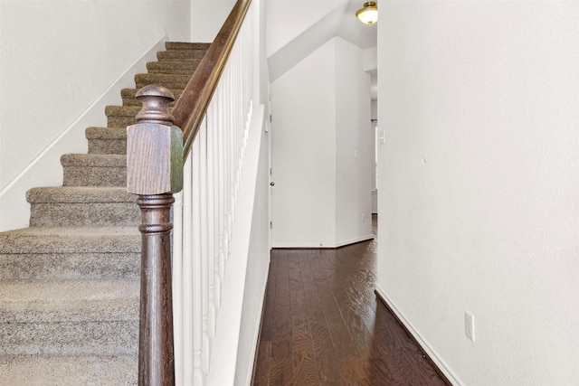 staircase with baseboards and wood finished floors