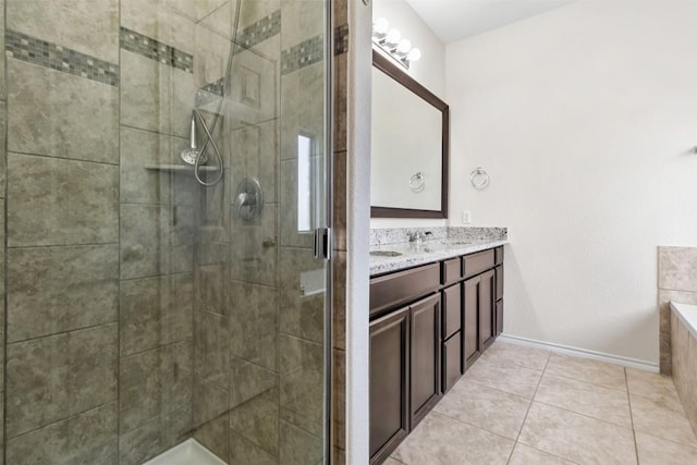 full bath featuring a shower stall, baseboards, tile patterned flooring, and double vanity